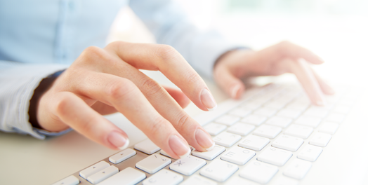 hands typing on white keyboard