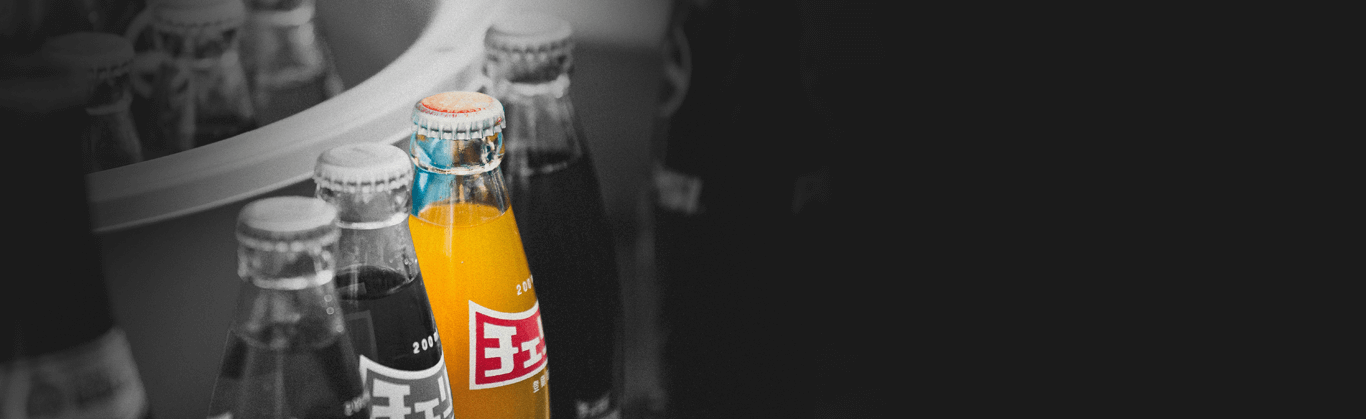 orange bottled soda among grey bottles